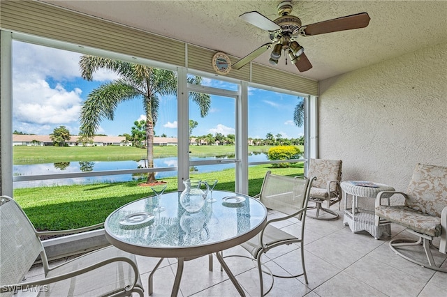 sunroom with a water view and ceiling fan