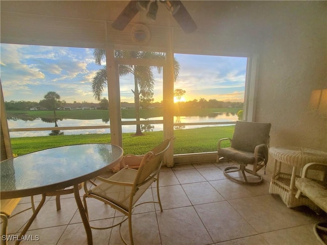 sunroom with a water view and ceiling fan