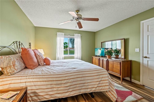 bedroom with ceiling fan, a textured ceiling, and light wood-type flooring