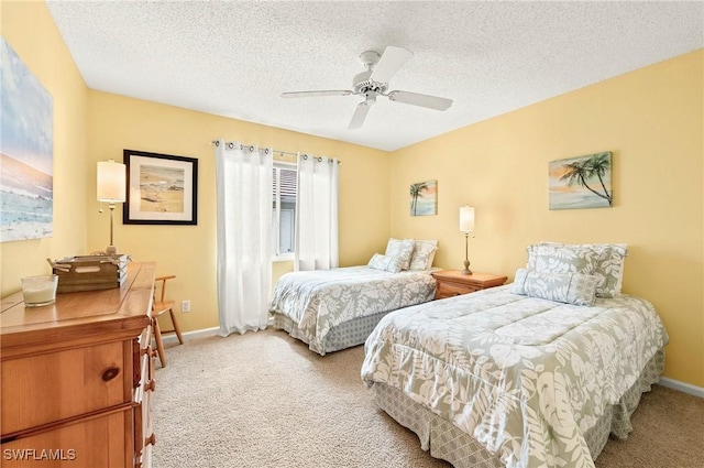 carpeted bedroom featuring ceiling fan and a textured ceiling