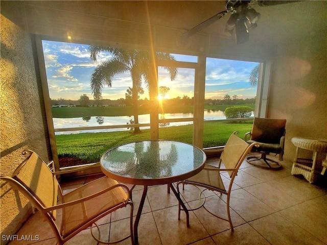 sunroom featuring a water view