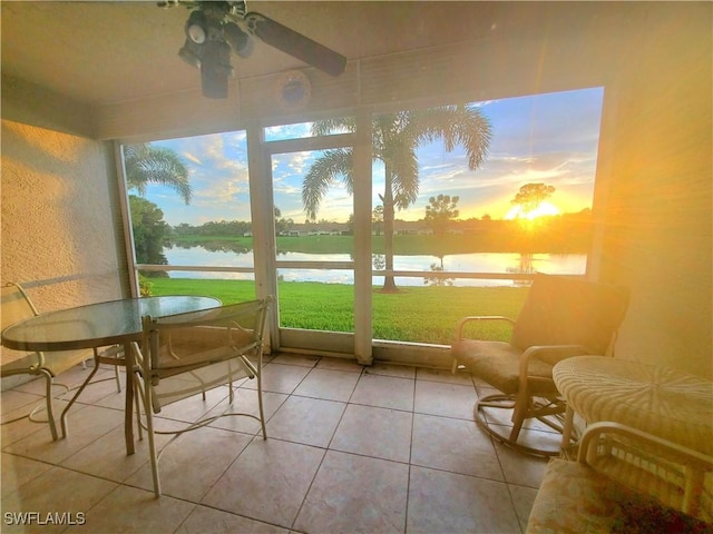 sunroom / solarium with a water view, plenty of natural light, and ceiling fan