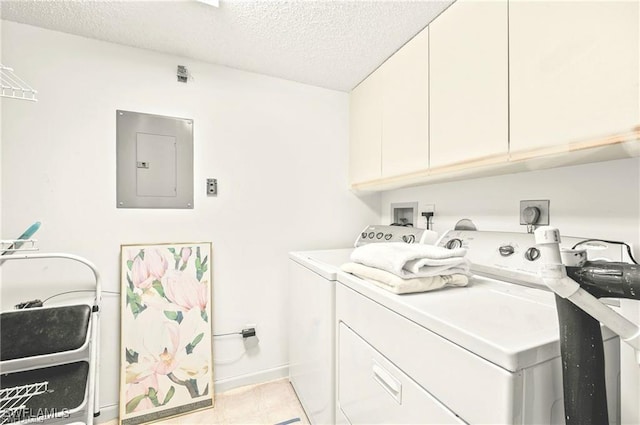 washroom featuring cabinets, washing machine and clothes dryer, electric panel, and a textured ceiling