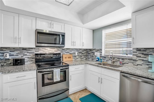 kitchen with sink, backsplash, stainless steel appliances, and white cabinets