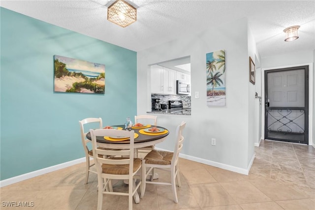 dining space with light tile patterned floors and a textured ceiling