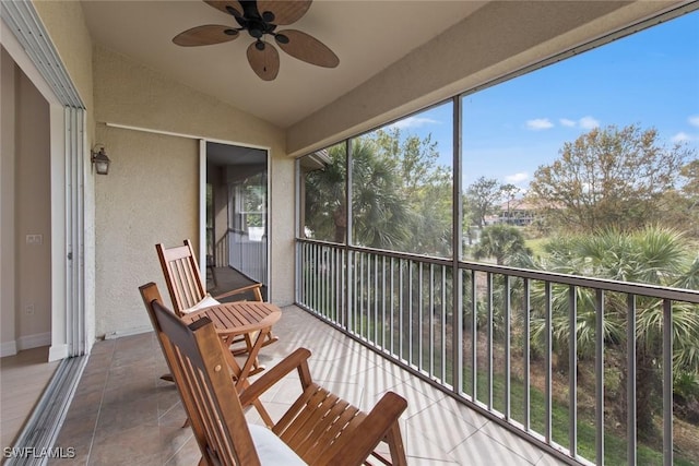 sunroom featuring ceiling fan, vaulted ceiling, and a healthy amount of sunlight