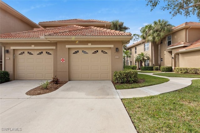 mediterranean / spanish home featuring a garage and a front lawn