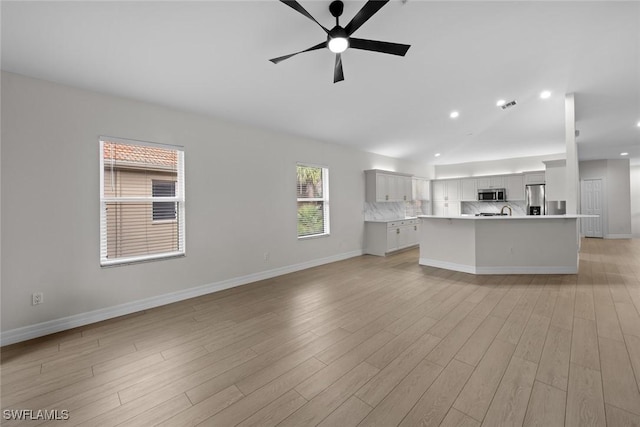 unfurnished living room with ceiling fan and light wood-type flooring