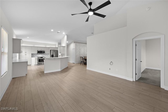 unfurnished living room with ceiling fan and light hardwood / wood-style flooring