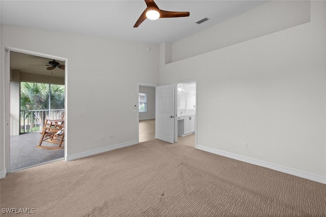 spare room featuring vaulted ceiling, light colored carpet, and ceiling fan