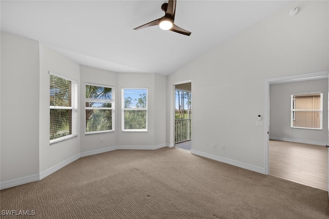 spare room featuring vaulted ceiling, light carpet, and ceiling fan