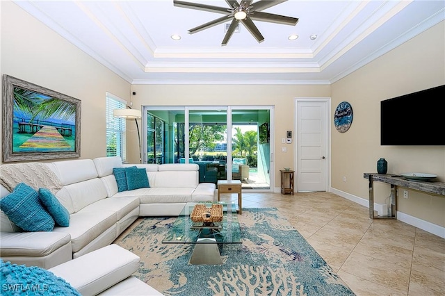 living room with ornamental molding, a raised ceiling, ceiling fan, and light tile patterned flooring