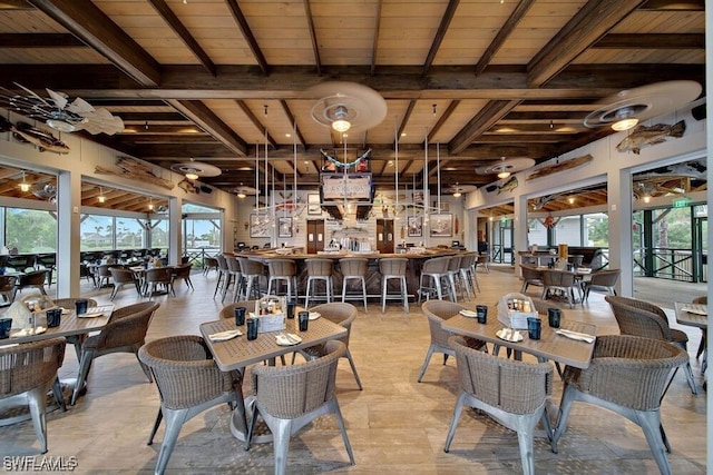 dining space with beamed ceiling, bar, and wooden ceiling