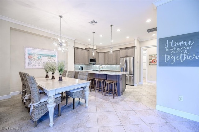 tiled dining room featuring ornamental molding, sink, and a notable chandelier