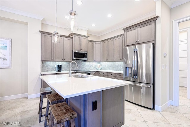 kitchen featuring sink, a breakfast bar area, decorative light fixtures, a center island with sink, and appliances with stainless steel finishes