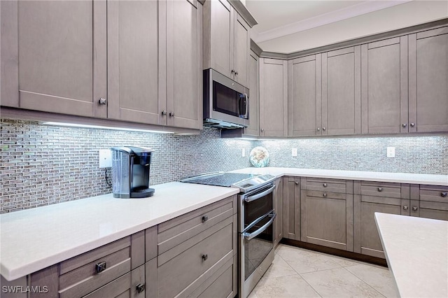 kitchen featuring ornamental molding, stainless steel appliances, light tile patterned floors, and backsplash