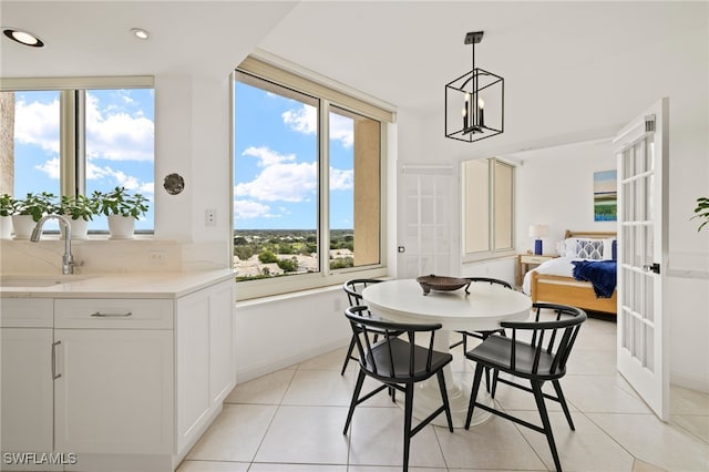 dining area featuring light tile patterned flooring, sink, and a notable chandelier