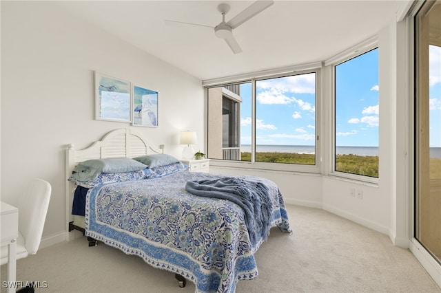 bedroom with a water view, ceiling fan, and light carpet