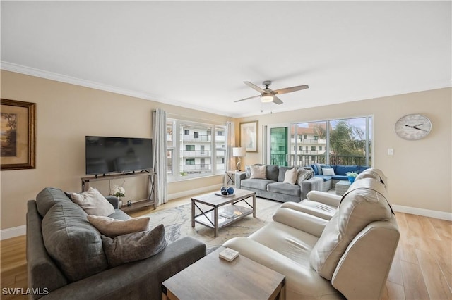 living room featuring crown molding, ceiling fan, light hardwood / wood-style flooring, and a wealth of natural light