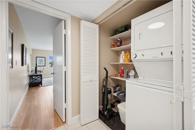 washroom featuring light hardwood / wood-style floors and stacked washer / dryer