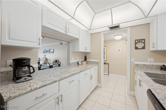 kitchen featuring sink, light tile patterned floors, dishwasher, light stone countertops, and white cabinets