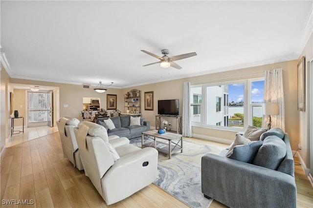 living room with ornamental molding, ceiling fan, and light hardwood / wood-style flooring