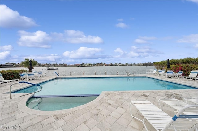 view of swimming pool featuring a water view and a patio area