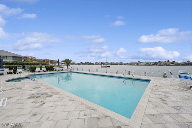 view of pool featuring a patio area and a water view