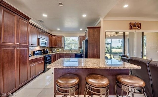 kitchen featuring light stone counters, light tile patterned floors, ornamental molding, stainless steel appliances, and backsplash