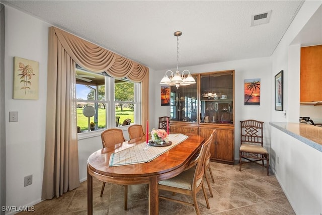 dining room with an inviting chandelier and a textured ceiling