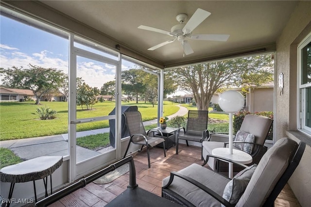 sunroom with a healthy amount of sunlight and ceiling fan