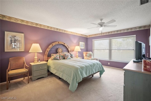 bedroom featuring ceiling fan, light carpet, and a textured ceiling