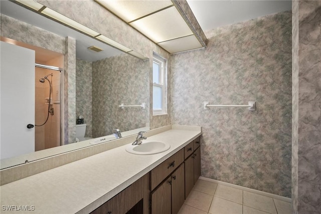 bathroom featuring vanity, tile patterned floors, toilet, and walk in shower