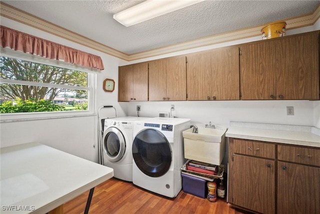 washroom with sink, cabinets, a textured ceiling, dark hardwood / wood-style flooring, and independent washer and dryer