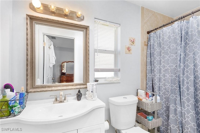 bathroom with vanity, a shower with shower curtain, and toilet