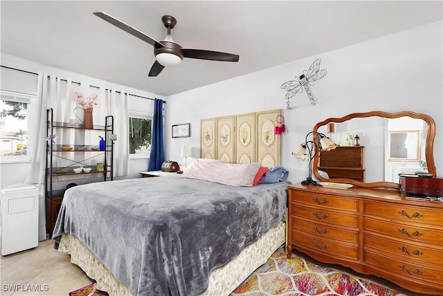 bedroom with multiple windows, light tile patterned floors, and ceiling fan