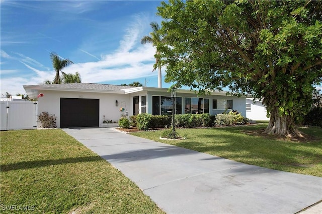 ranch-style house featuring a garage and a front lawn