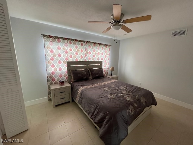 tiled bedroom featuring ceiling fan