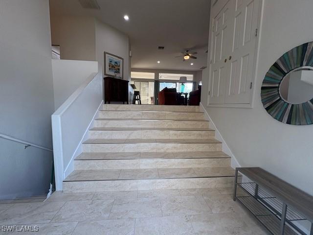 staircase featuring ceiling fan