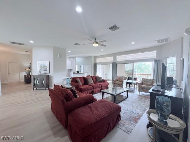 living room with ceiling fan and light hardwood / wood-style flooring