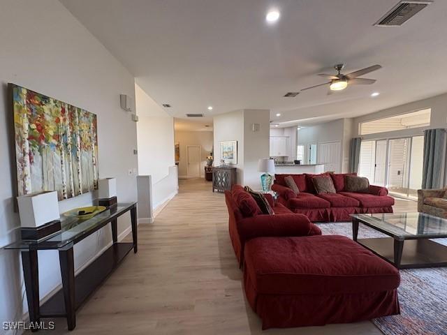 living room with light hardwood / wood-style flooring and ceiling fan