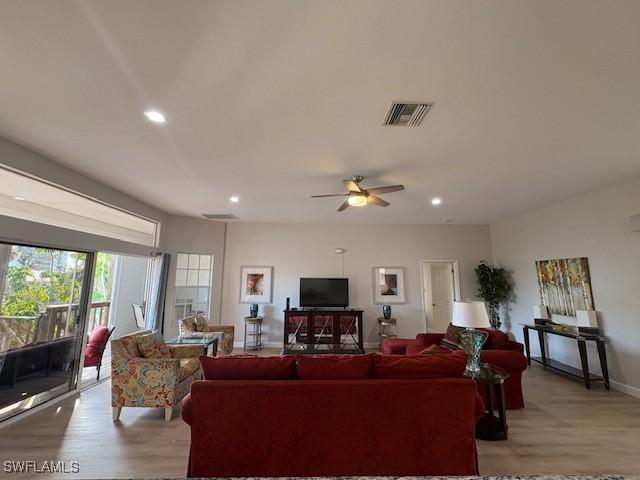 living room with ceiling fan and light wood-type flooring