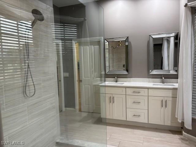 bathroom with vanity and a tile shower