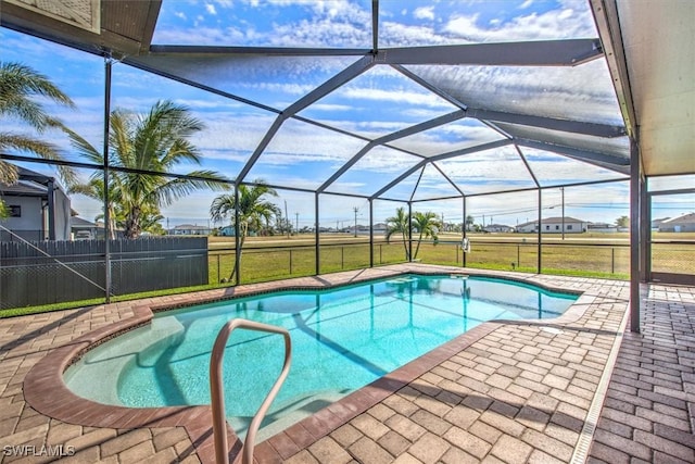 view of pool featuring a patio, glass enclosure, and a lawn