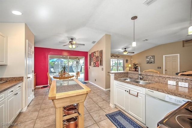 kitchen featuring sink, hanging light fixtures, white cabinets, light tile patterned flooring, and vaulted ceiling