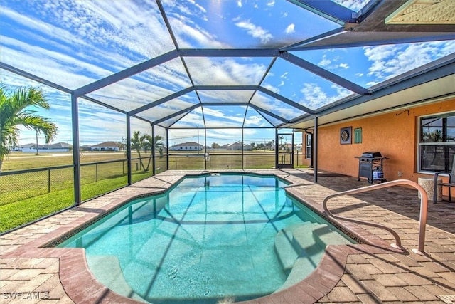 view of pool featuring a grill, a lanai, a patio area, and a lawn