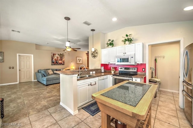 kitchen with sink, white cabinetry, stainless steel appliances, vaulted ceiling, and kitchen peninsula