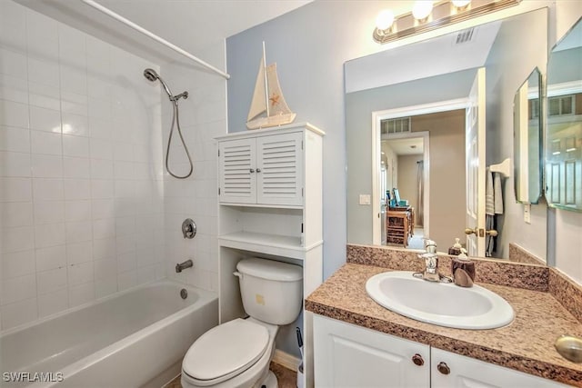 full bathroom featuring tiled shower / bath combo, vanity, and toilet