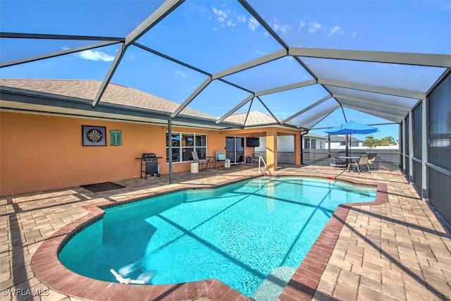 view of pool featuring a lanai, a grill, and a patio area