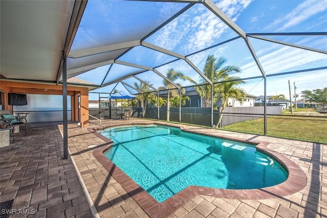 view of pool with a lanai, a lawn, and a patio